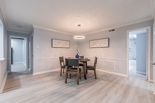Dining area with baseboards, visible vents, ornamental molding, and light wood finished floors | Image 7