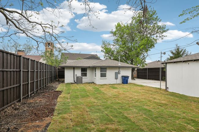 Rear view of property featuring a fenced backyard, brick siding, a lawn, and a patio | Image 31