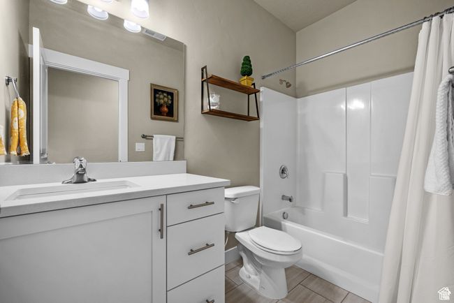 Full bathroom with vanity, visible vents, toilet, baseboards, and shower / bath combo | Image 20