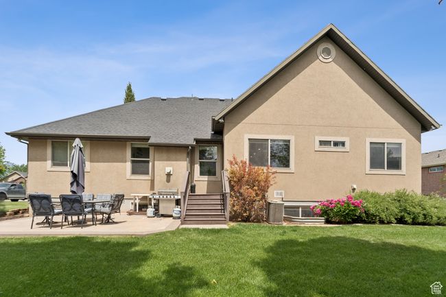 Rear view of property featuring stucco siding, a lawn, a patio, and roof with shingles | Image 35