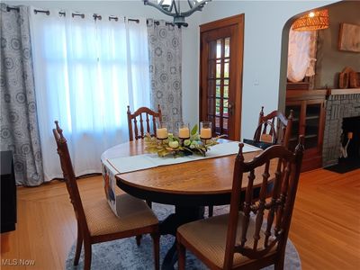 Dining room with light hardwood / wood-style flooring and a brick fireplace | Image 2