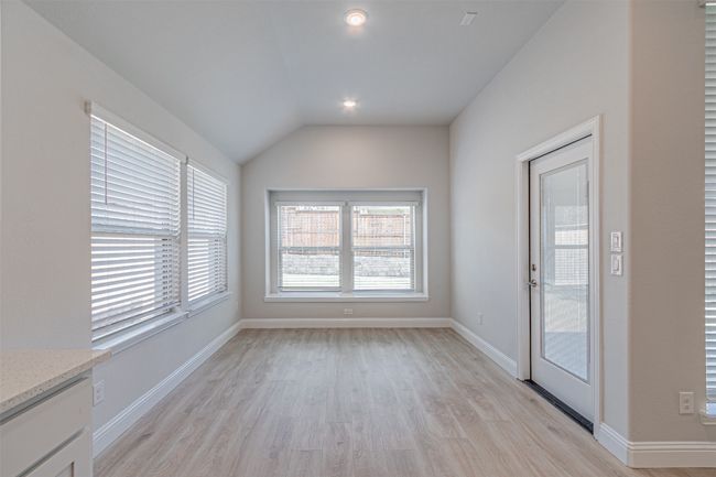 Unfurnished dining area with light wood finished floors, vaulted ceiling, and recessed lighting | Image 19