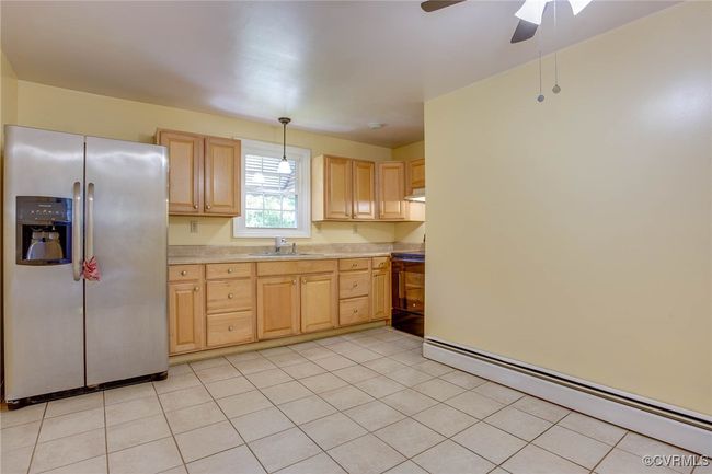 Eat-in Kitchen featuring pendant lighting, ceiling fan, light tile patterned floors, and stainless steel refrigerator with ice dispenser | Image 19
