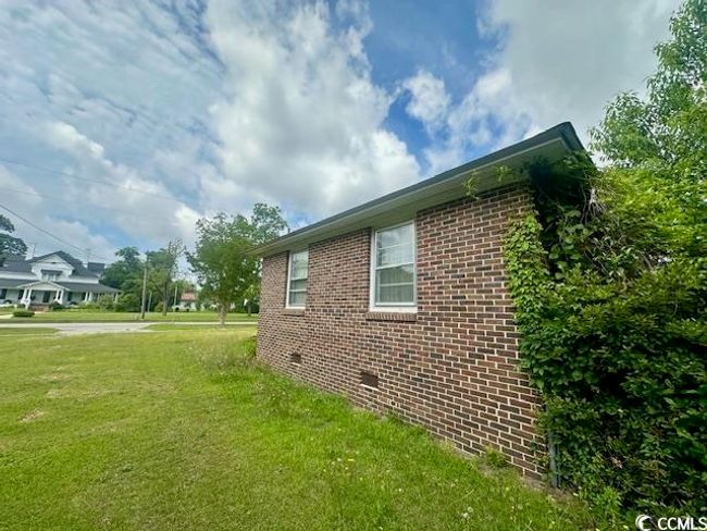 View of side of property featuring brick siding and a yard | Image 6