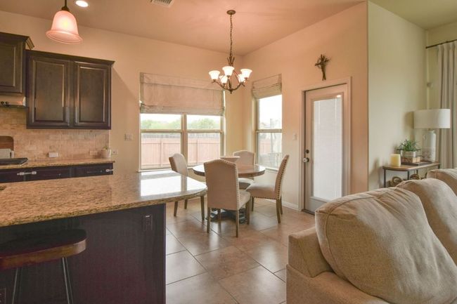 Dining room with light tile patterned flooring, recessed lighting, a chandelier, and visible vents | Image 11
