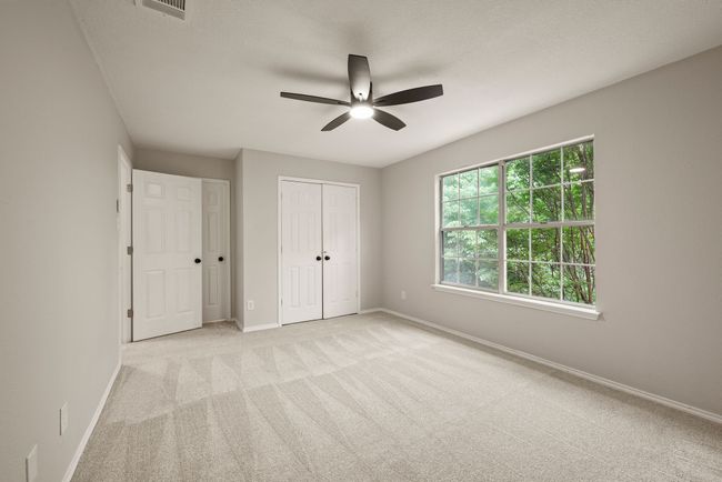 All of the bedrooms are spacious with large windows, fresh carpet, and modern ceiling fans. | Image 30