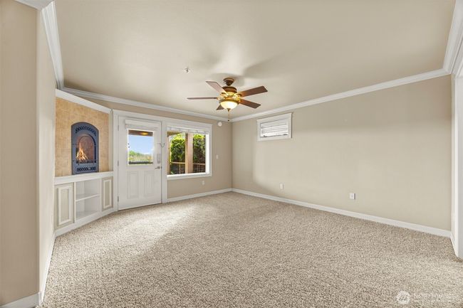 Spacious primary bedroom with door out to covered patio and cozy gas fireplace and built ins. | Image 12