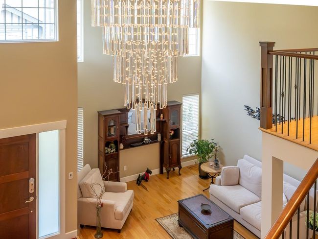 Living room with a towering ceiling and wood finished floors | Image 6