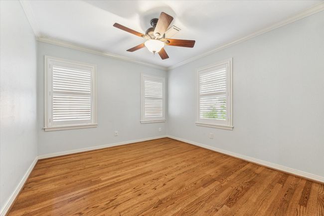 Secondary bedroom with ceiling fan, lots of great natural light and hardwood floors. | Image 7