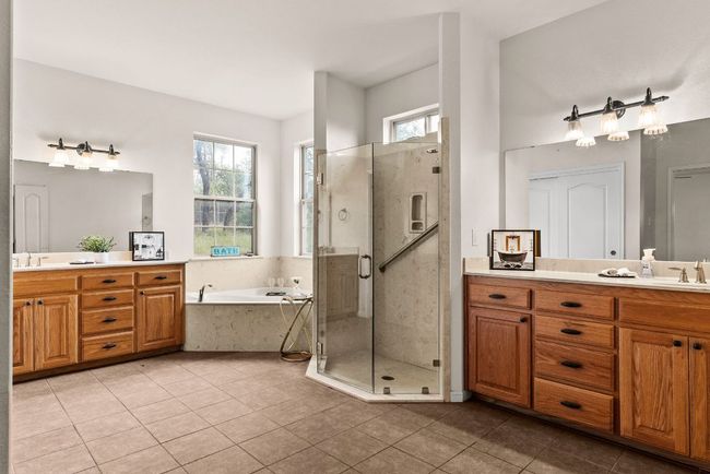 Full bathroom with two vanities, a shower stall, and tile patterned flooring | Image 25