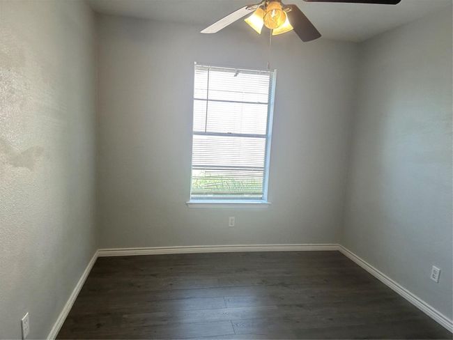 Spare room with dark wood finished floors, ceiling fan, and baseboards | Image 12