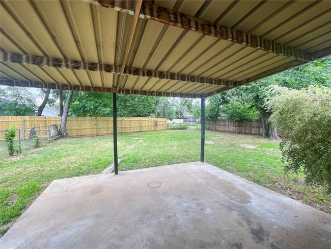 Fenced backyard with a patio area | Image 18