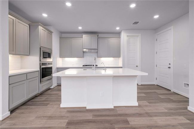Kitchen featuring stainless appliances with gray cabinetry, and tasteful backsplash | Image 7