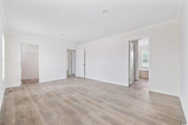 Empty room featuring crown molding, light wood-style floors, and recessed lighting | Image 24