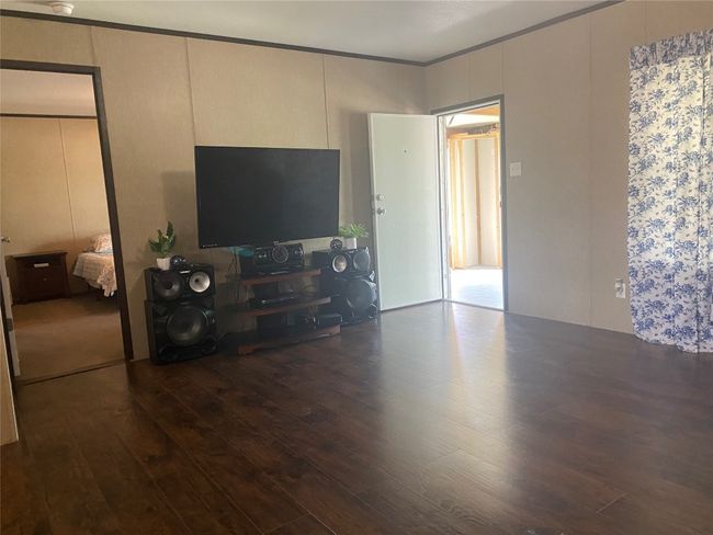Living area with wood finished floors and crown molding | Image 5