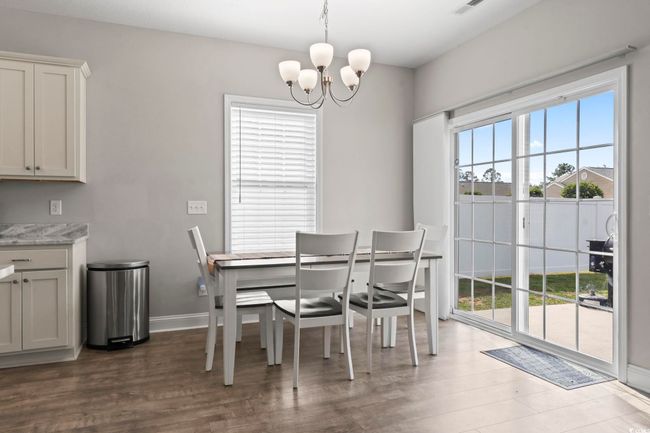 Dining space with dark wood-style flooring, baseboards, and an inviting chandelier | Image 16