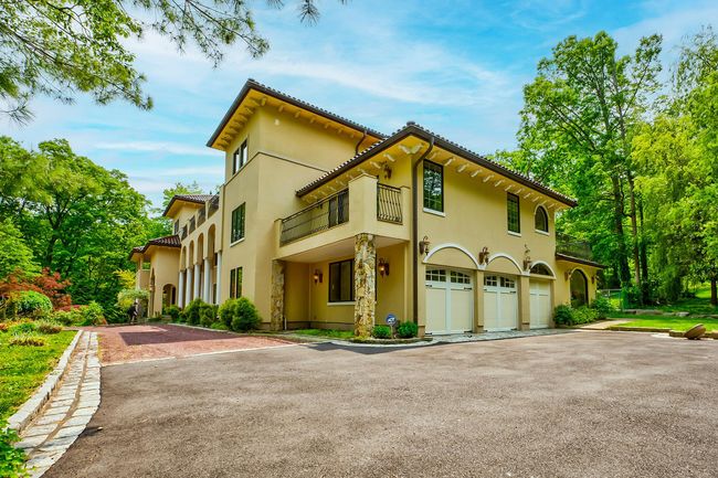 Mediterranean / spanish home featuring driveway, stone siding, a tile roof, and stucco siding | Image 19