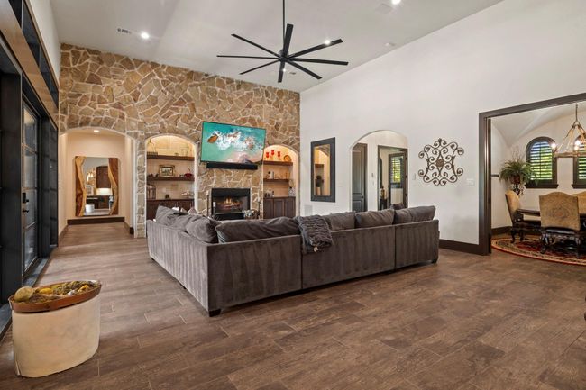 Living room with gas stone fireplace and accent wall. Area to your right is your dining room with double wood doors. | Image 13