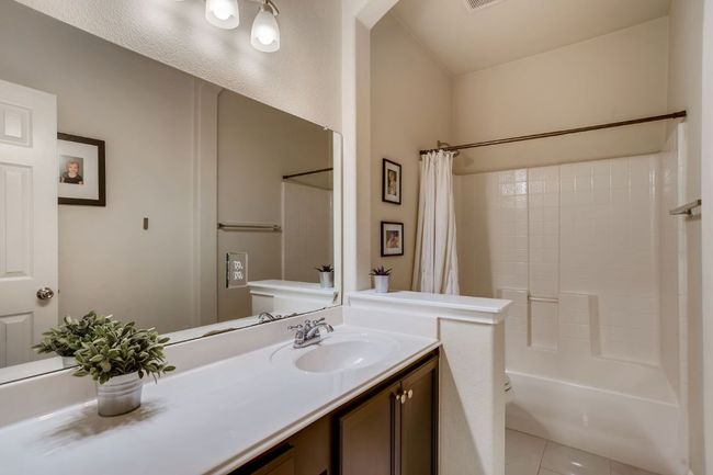 Full bath featuring vanity, shower / tub combo, and tile patterned flooring | Image 22