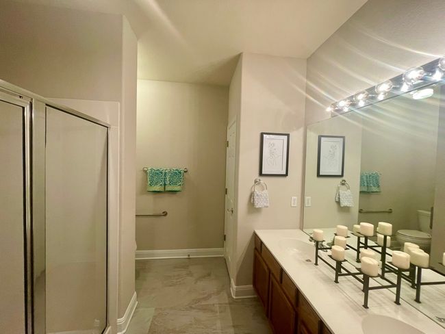 Full bathroom with marble look tile flooring, double vanity, and a stall shower | Image 9