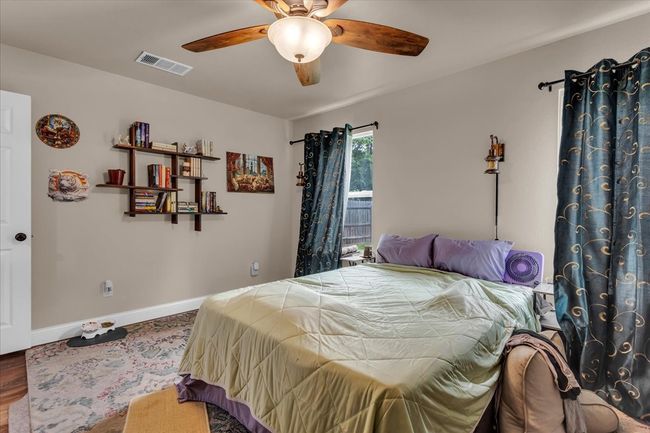 Bedroom with a ceiling fan and wood finished floors | Image 14