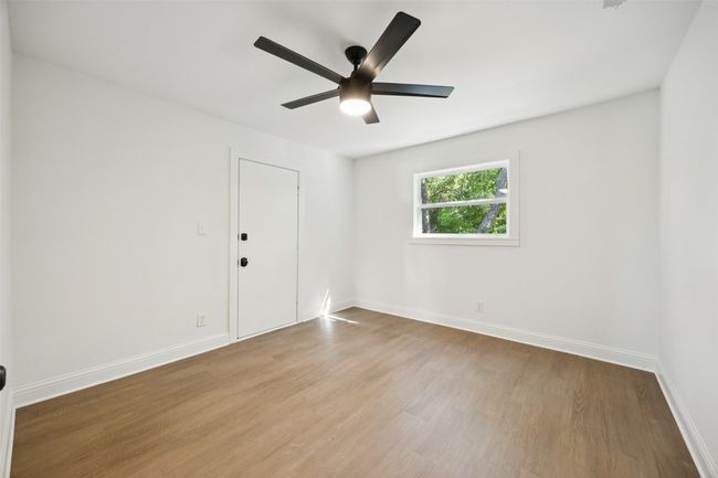 Empty room with wood finished floors and ceiling fan | Image 11