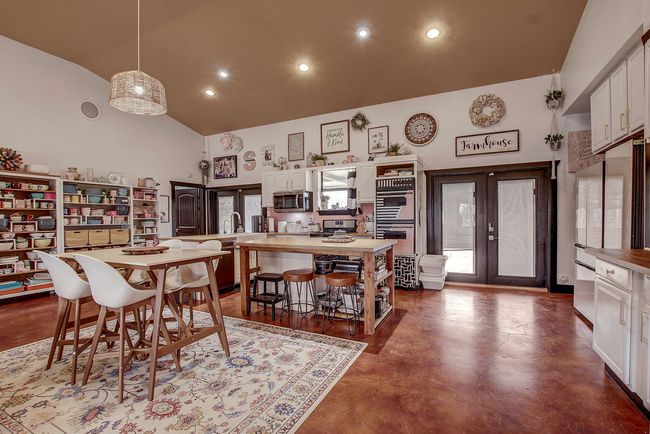 Dining space featuring high vaulted ceiling, recessed lighting, french doors, and concrete floors | Image 11