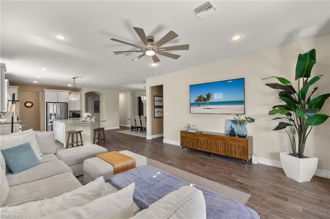 Living room featuring ceiling fan and dark wood-type flooring | Image 5