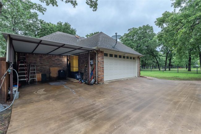 View of property exterior with concrete driveway, an attached garage, brick siding, and a shingled roof | Image 6