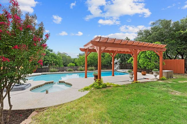 View of swimming pool with an in-ground hot tub, a pergola, a fenced backyard, and a patio | Image 31