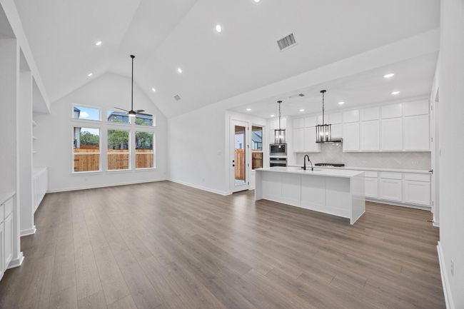 Unfurnished living room featuring recessed lighting, dark wood-style flooring, a chandelier, ceiling fan, and high vaulted ceiling | Image 20