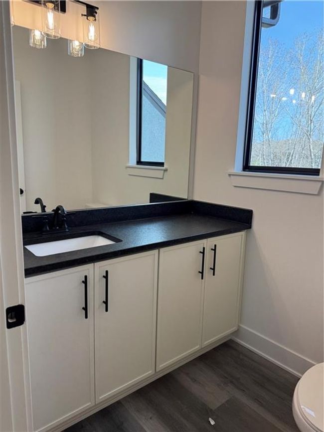 Bathroom featuring baseboards, toilet, wood finished floors, and vanity | Image 33