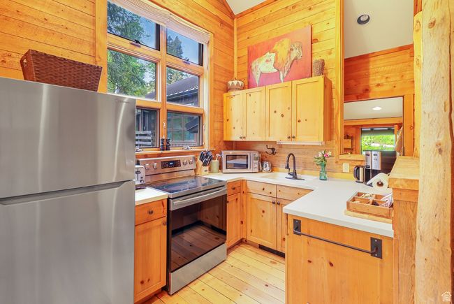 Full kitchen with solid surface countertops, stainless appliances and picture windows | Image 21