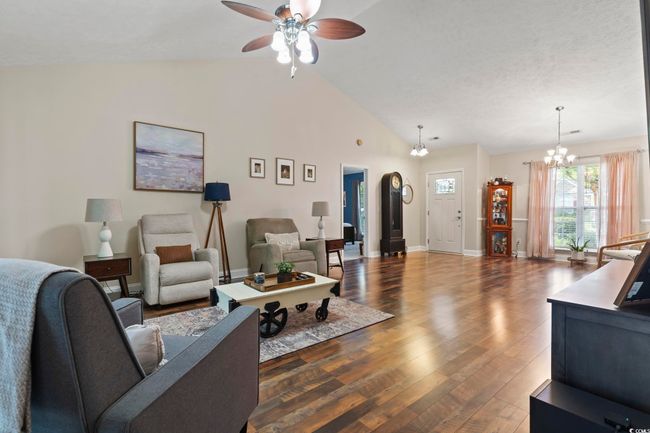 Living area featuring a ceiling fan, dark wood finished floors, a chandelier, and high vaulted ceiling | Image 4