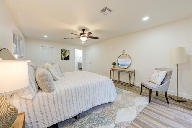The freshly painted walls and modern trim create a clean, contemporary feel, making it a relaxing space to unwind. Ample room is provided for a king-sized bed and additional furniture, creating a comfortable and cozy atmosphere. This peaceful retreat is perfectly designed to complement the home’s updated finishes and open layout. | Image 17