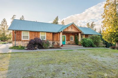 Quintessential northwest style home with its wood and stone exterior. | Image 2