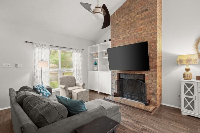 Imagine curling up by the floor-to-ceiling brick fireplace, the warmth radiating as you unwind in this spacious, light-filled room—it's the perfect spot to escape and feel at home | Image 6