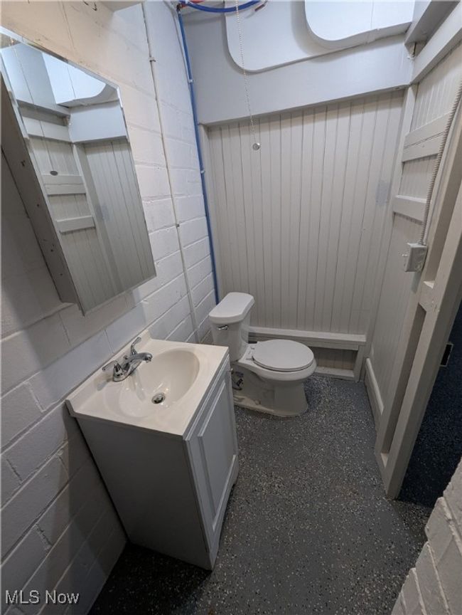 Bathroom featuring vanity, concrete block wall, and toilet | Image 27