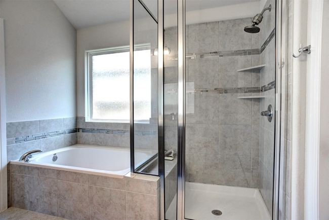 Full bathroom featuring a bath and a stall shower | Image 23
