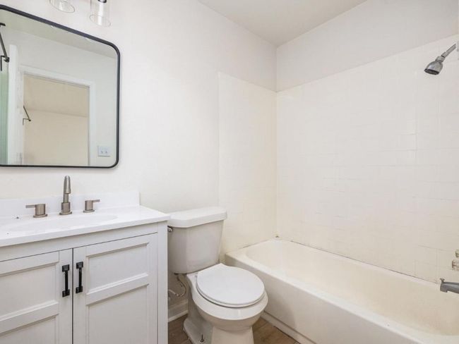 Bathroom with toilet, vanity, bathing tub / shower combination, and wood finished floors | Image 23