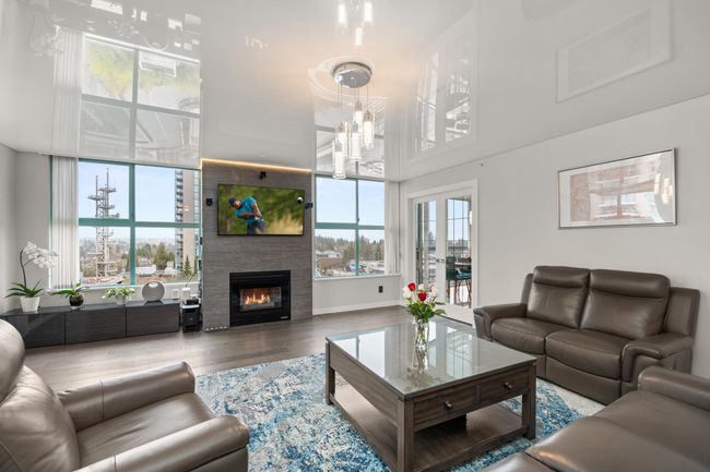 Living room with a fireplace and wood finished floors | Image 7