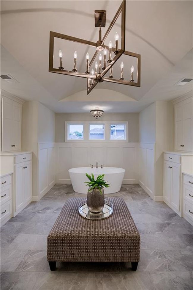 Bathroom with tile flooring, a notable chandelier, vanity, and a washtub | Image 32