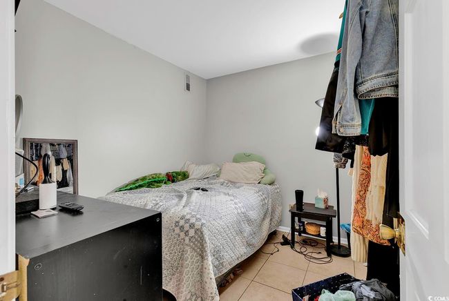 Bedroom with light tile patterned flooring, visible vents, and baseboards | Image 19