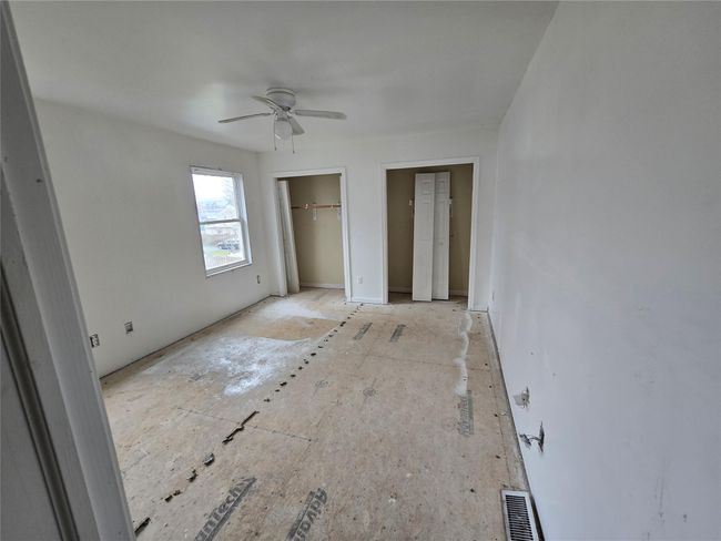 Unfurnished bedroom with multiple closets and a ceiling fan | Image 4