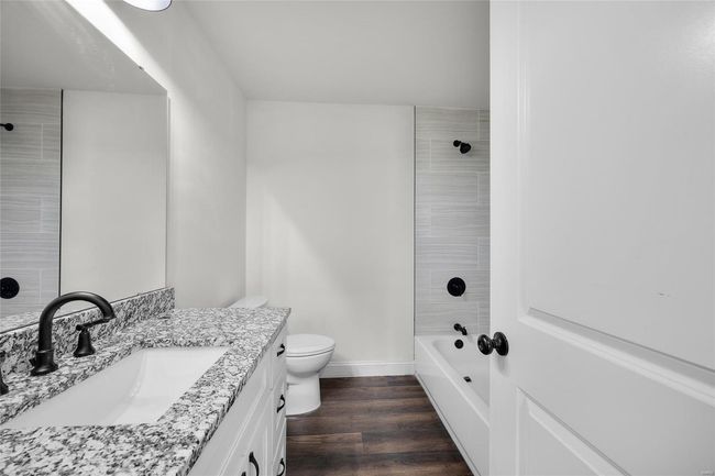 Full bath with vanity, wood finished floors, toilet, baseboards, and bathtub / shower combination | Image 16