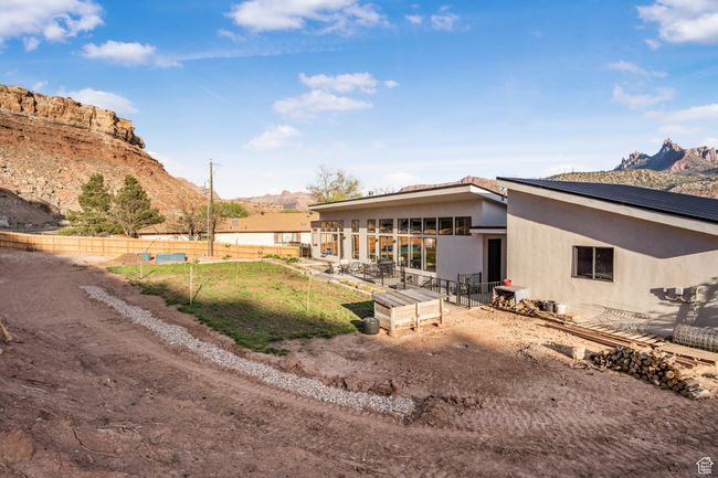 Rear view of house featuring a patio area, a mountain view, fence, and stucco siding | Image 47