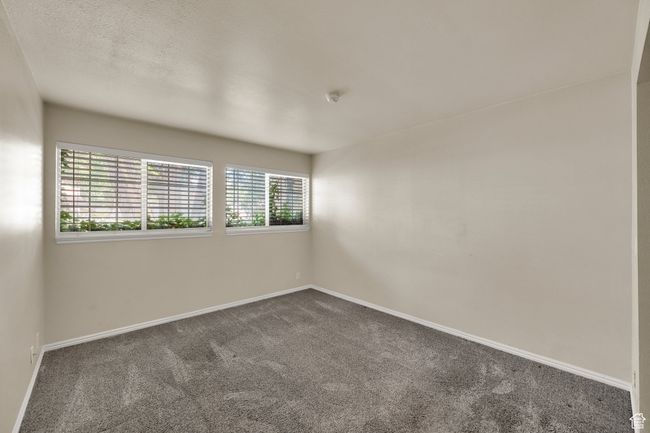 Bedroom featuring dark carpet and a smoke detector | Image 5