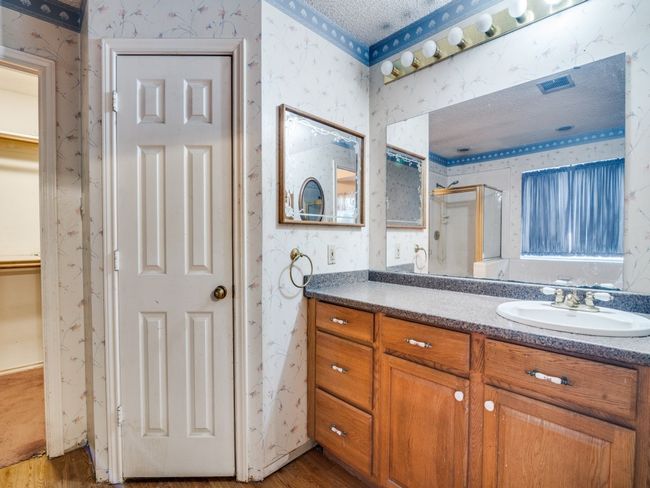 Bathroom featuring wallpapered walls, wood finished floors, a shower stall, and vanity | Image 10