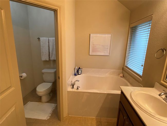 Full bath featuring vanity, a garden tub, toilet, and tile patterned flooring | Image 18