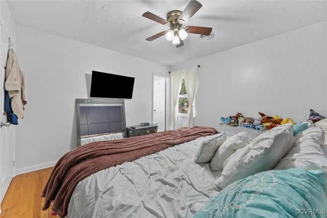 Bedroom featuring wood finished floors, ceiling fan, and baseboards | Image 21